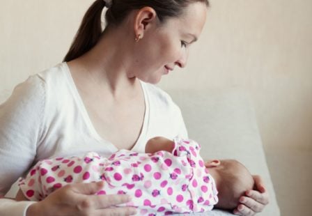 mother breastfeeding her baby on a boppy pillow